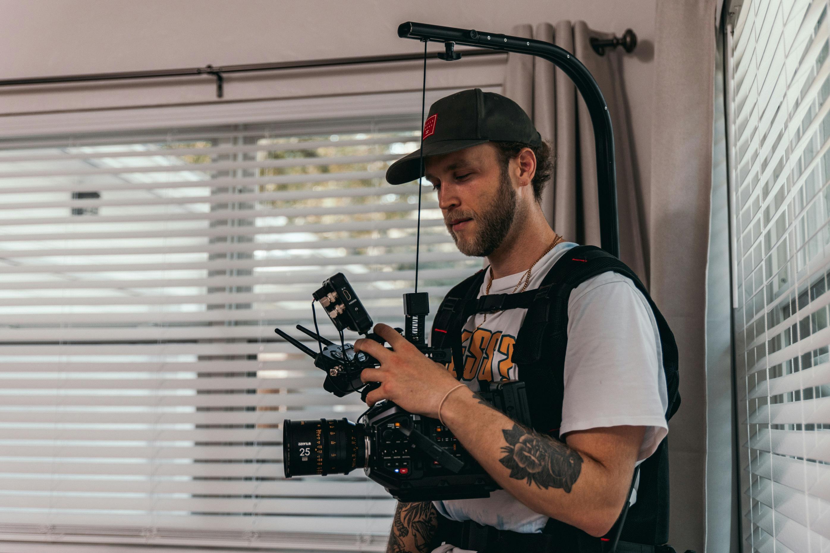 a man wearing camera harness holding a camera