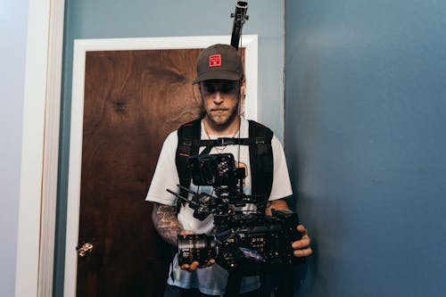 A Cameraman Recording Using a Camera near a Door