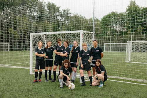Women Soccer Players near the Goal Post