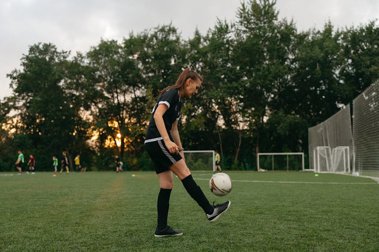 Side View Of A Woman Playing Soccer 