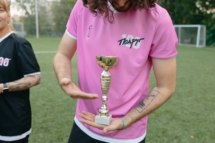 A Proud Coach Showing Off A Trophy