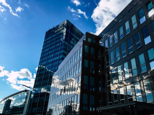 Free Low-angle Photography of Curtain Wall Building Taken Under White Clouds and Blue Sky Stock Photo