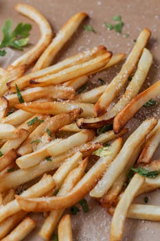 Delicious golden french fries seasoned with herbs and salt, perfect for fast food promotions.