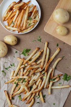 Crispy golden French fries seasoned with herbs, perfect for a snack or side dish.