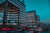 日落时分，一条繁华的城市街道上，现代建筑与城市交通交相辉映，尽显建筑的宏伟