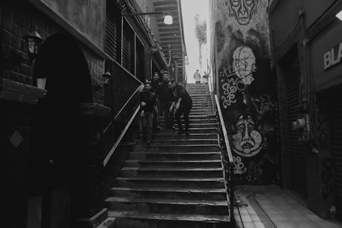 Monochrome Photo of Men Standing on Stairs
