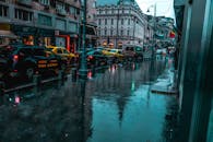 一条交通繁忙、建筑经典的潮湿城市街道，映衬出雨天平静的氛围