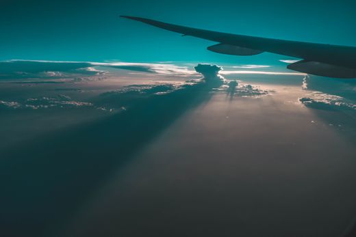 Aircraft wing above twilight cloud cover — photo by Alex Pham on Pexels