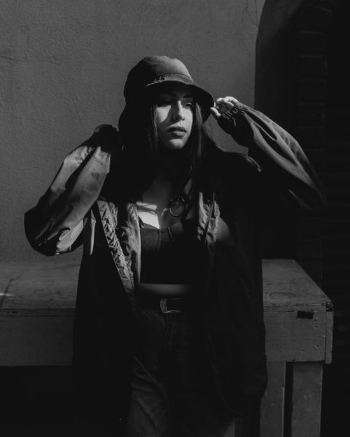 Free Chic black-and-white portrait of a stylish woman wearing a bucket hat and jacket. Stock Photo