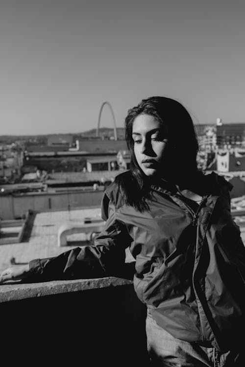 Alluring Woman in Jacket leaning in a Parapet