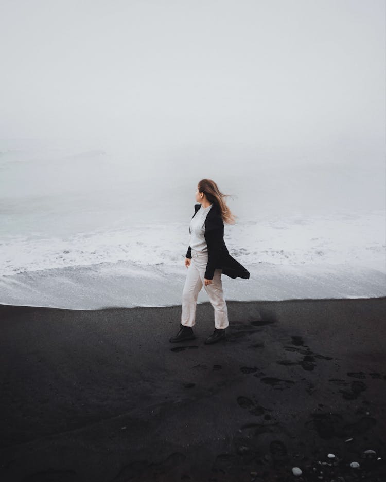 A Woman Walking Alone On Shore