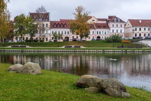 Free Charming waterfront view of colorful historic buildings in Minsk, Belarus, reflecting on calm river. Stock Photo