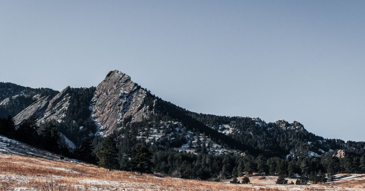 Breathtaking view of a snow-dusted mountain during winter, captured at sunrise.