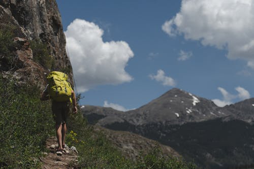 Free Man in Backpack Walking on the Mountain Stock Photo