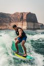 Man in Life Vest Surfboarding on Body of Water