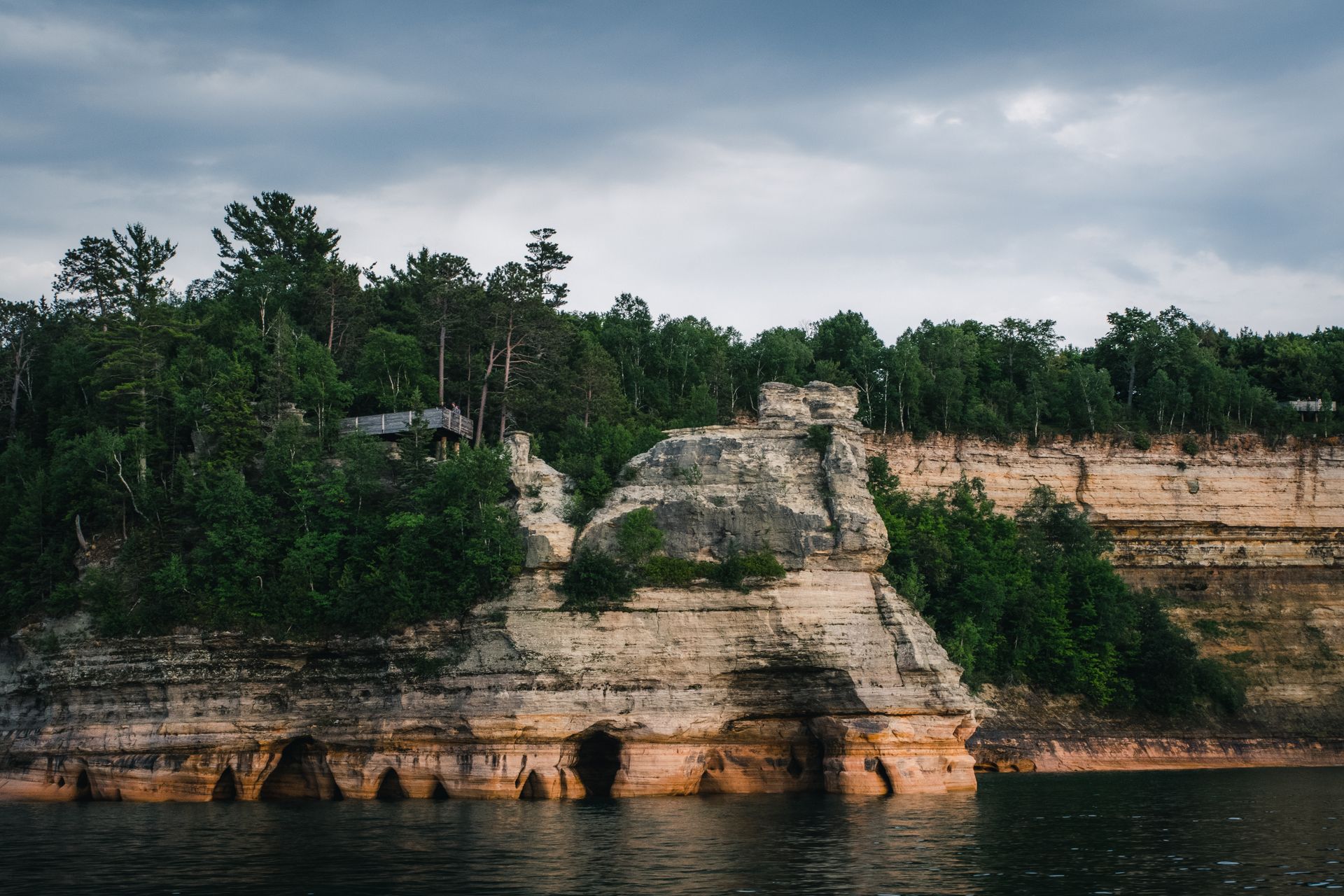 Scenic view of Pictured Rocks cliffs with lush forest above Lake Superior.