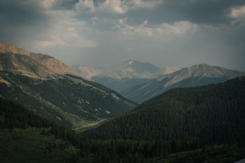 Free Serene mountain landscape with misty forests and distant peaks under gray skies, perfect for nature enthusiasts. Stock Photo