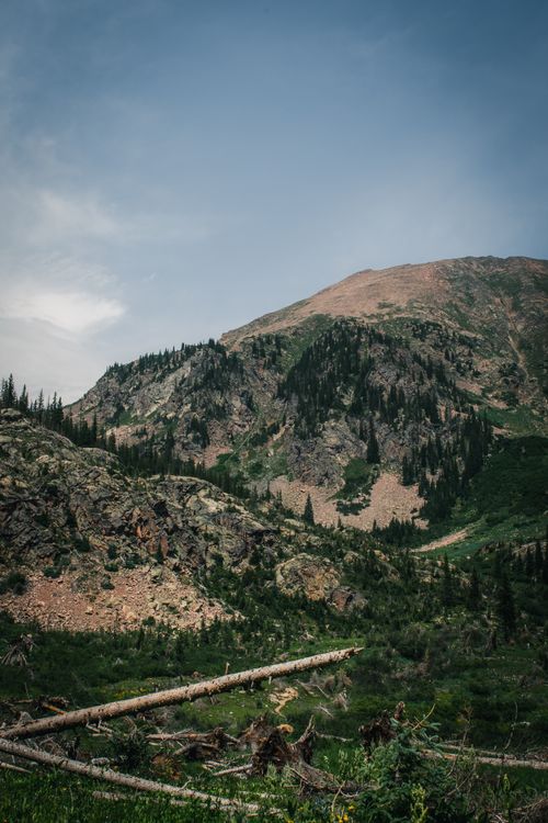 Free Explore the raw beauty of a rugged mountain landscape with lush forests and clear skies. Stock Photo