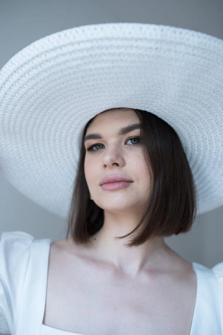 Young Brunette Woman Wearing A White Round Hat 