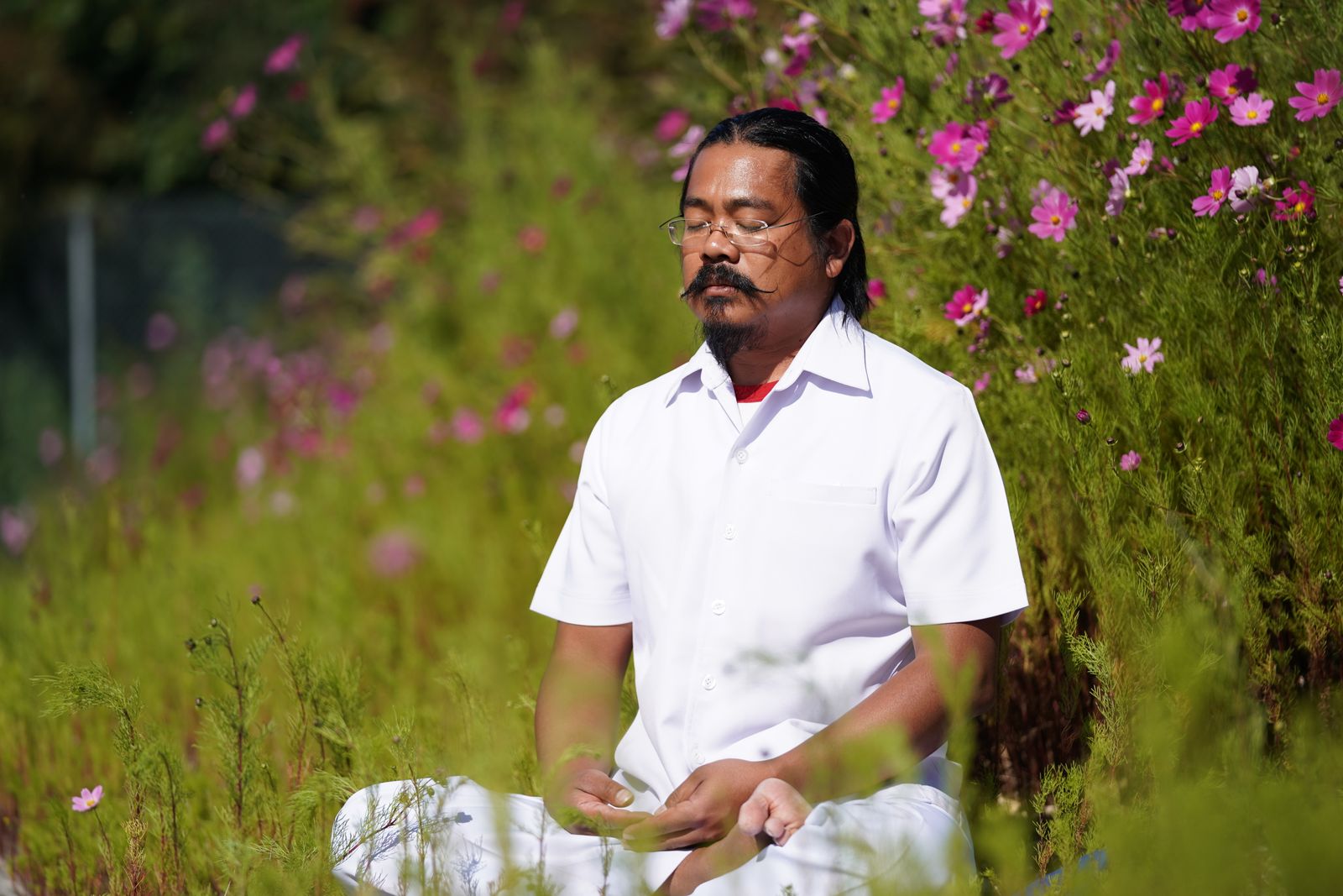 Person meditating in lotus position during raja yoga practice at sunrise