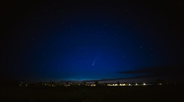 A stunning view of a comet streaking through the night sky over Groningen's horizon.