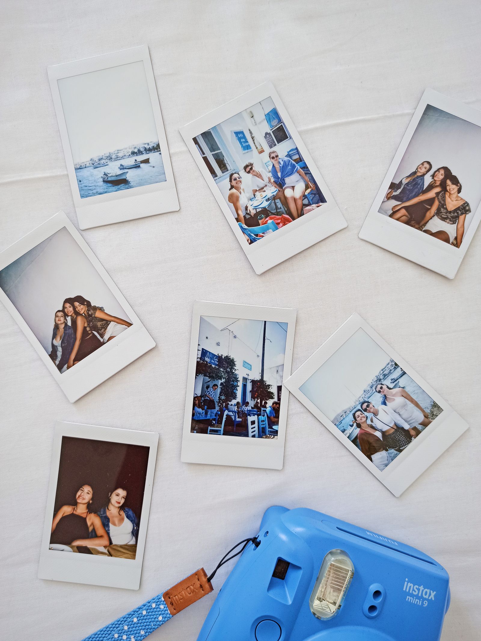 A collection of small instant-style photos spread out on a table, similar to how fans display photocards.
