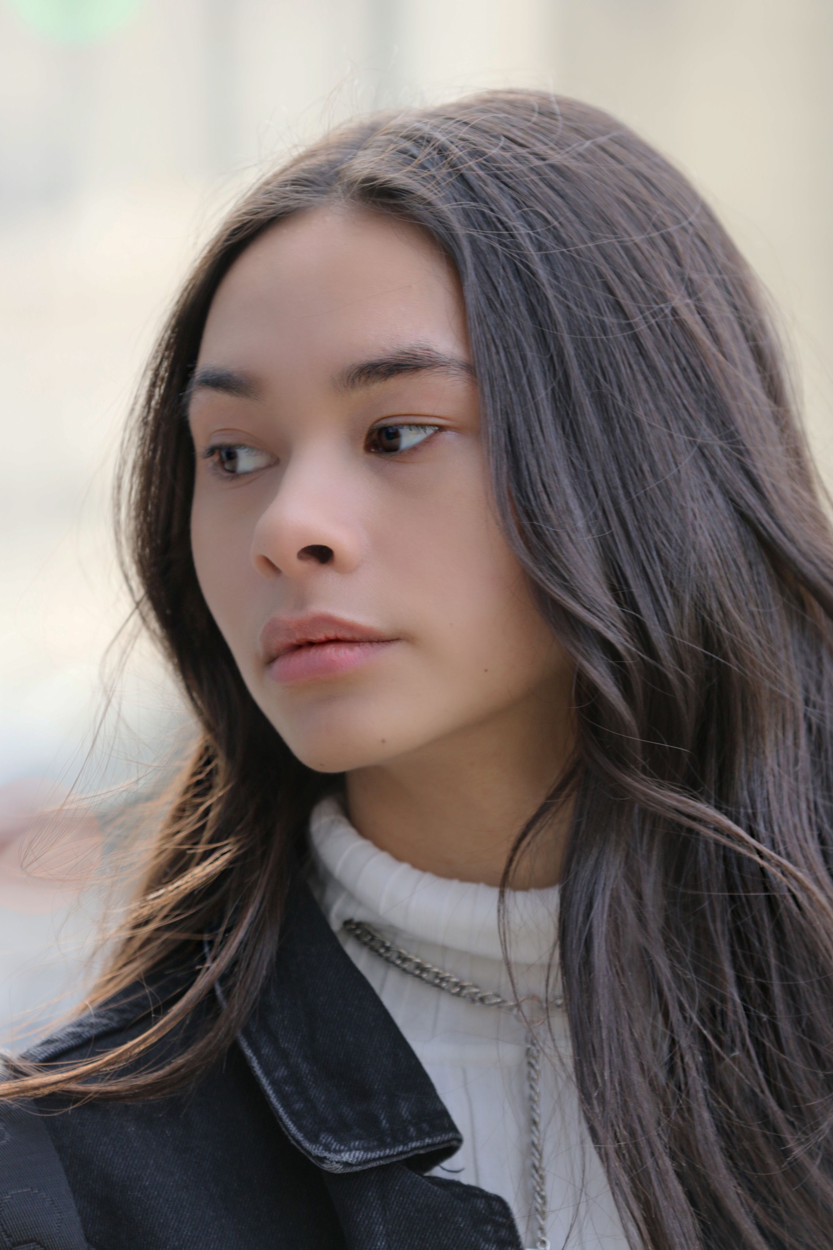 Profile portrait of a stylish young woman in urban New York setting.