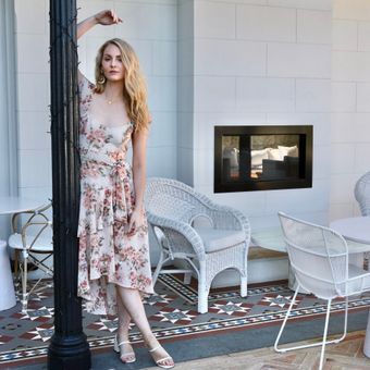 Guest in a floral midi dress on a porch — photo by Kate Branch on Pexels