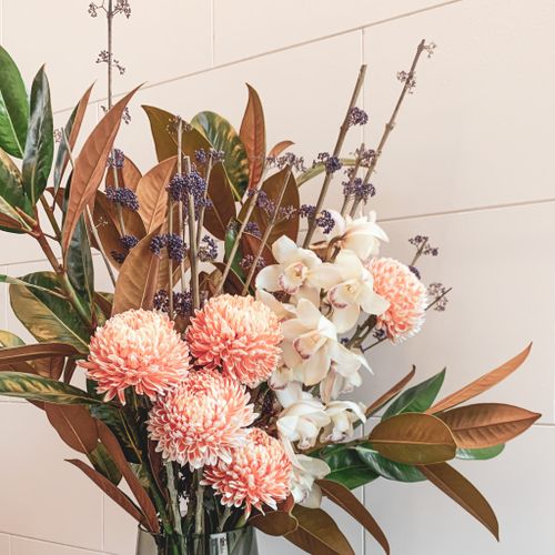 Free A sophisticated bouquet featuring orchids and chrysanthems against a neutral background. Stock Photo