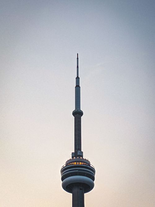 Free Vertical shot of the iconic CN Tower in Toronto, Canada, capturing its towering modern architecture against a clear sky. Stock Photo