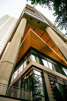 Low-angle shot of a modern building with a glass facade and urban design elements.