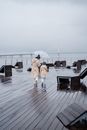 A Mother and Daughter Walking Together under an Umbrella