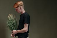 Man in Blue Crew Neck T-shirt Holding Green Plant