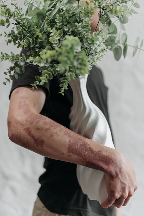 Man in Black T-shirt Holding Green Plant