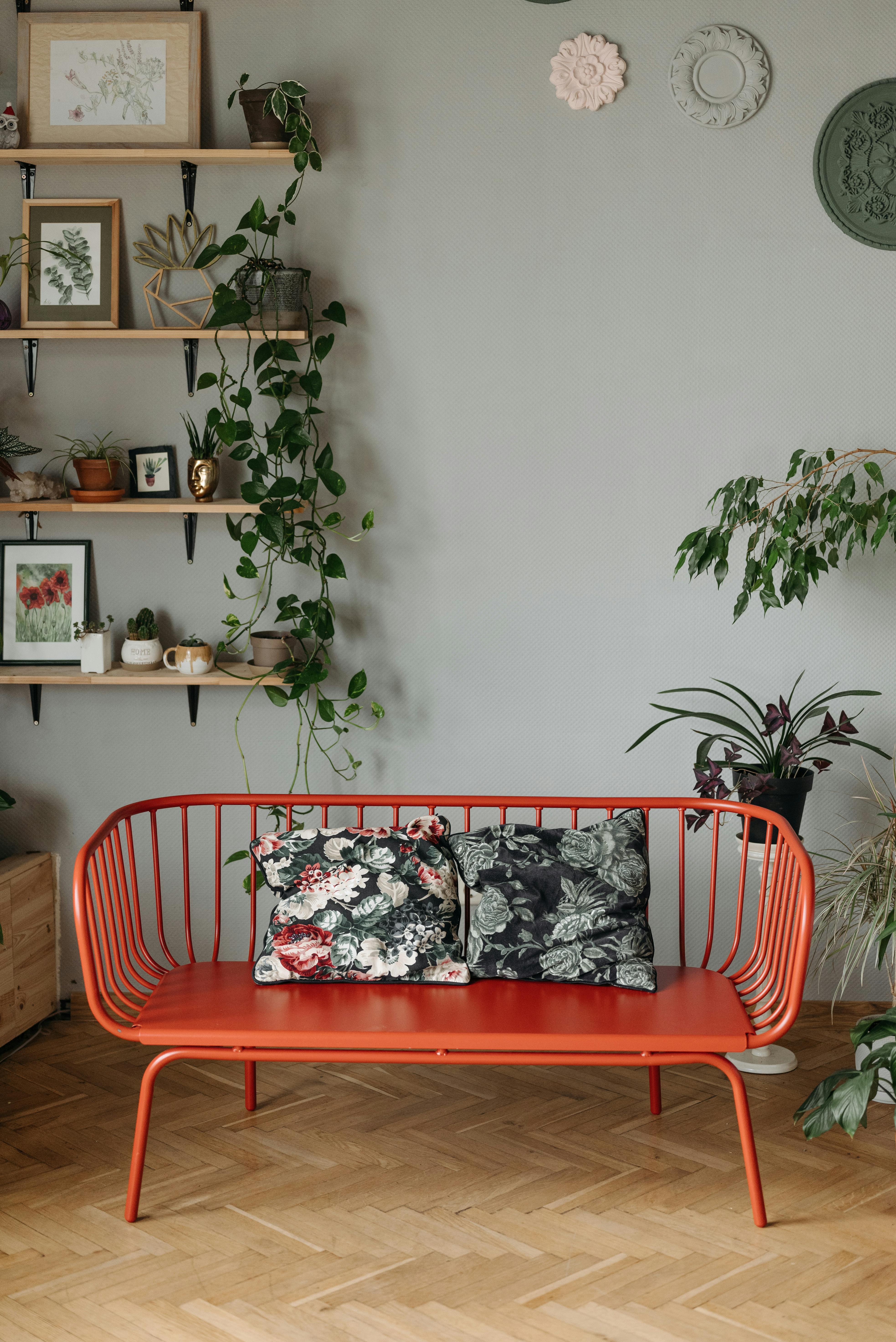 Stylish home interior featuring a vibrant red bench, plants, and decorative wall items.