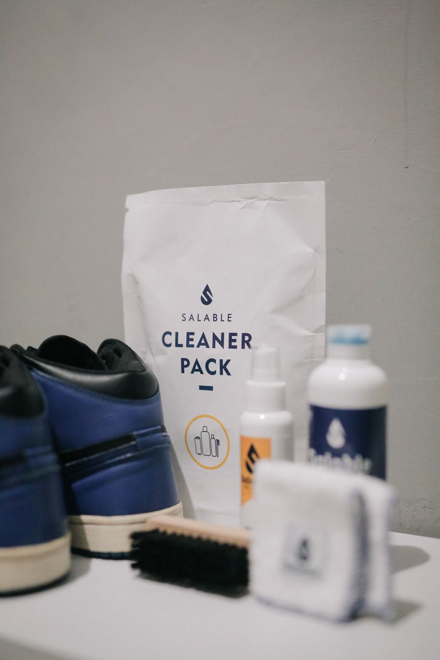 White sneakers being cleaned with a soft brush