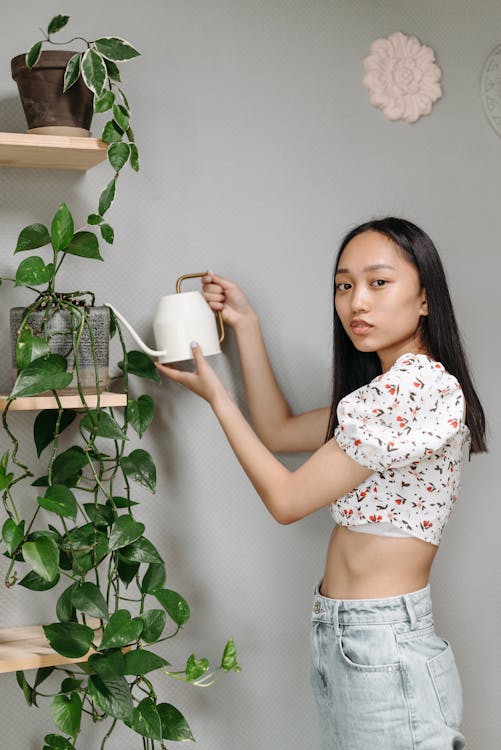 Free A Woman Watering Her Plant with a Watering Pot Stock Photo