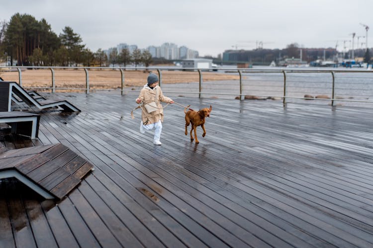 A Girl Running With Her Pet Dog