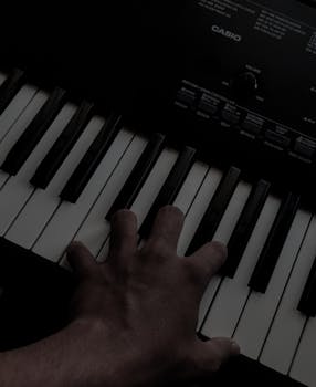 A hand playing keys on an electronic keyboard with visible branding, captured in a close-up shot.