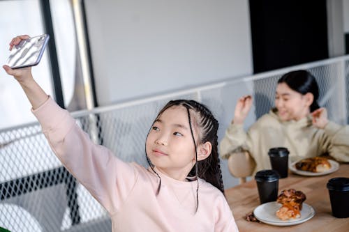 Free Girl in Pink Long Sleeve Shirt Sitting on Chair Stock Photo