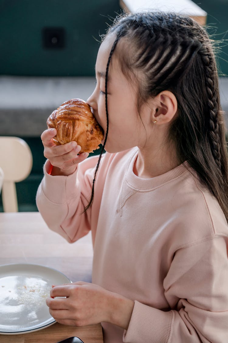 A Girl Eating A Muffin 