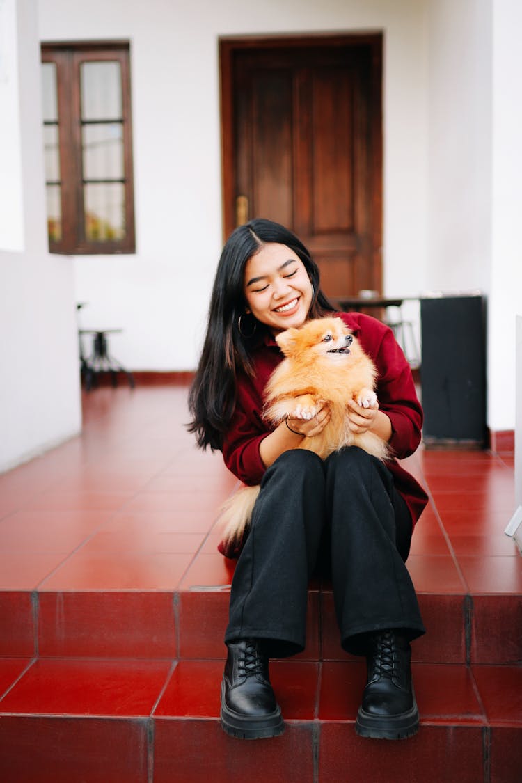 A Woman Petting Her Pomeranian Dog