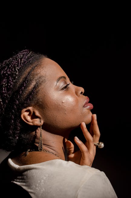 Close-up side profile of beautiful African woman with hand on chin, elegant and poised.