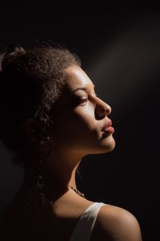 Close-up side profile of a woman in dramatic lighting against a dark background.. close, side, profile