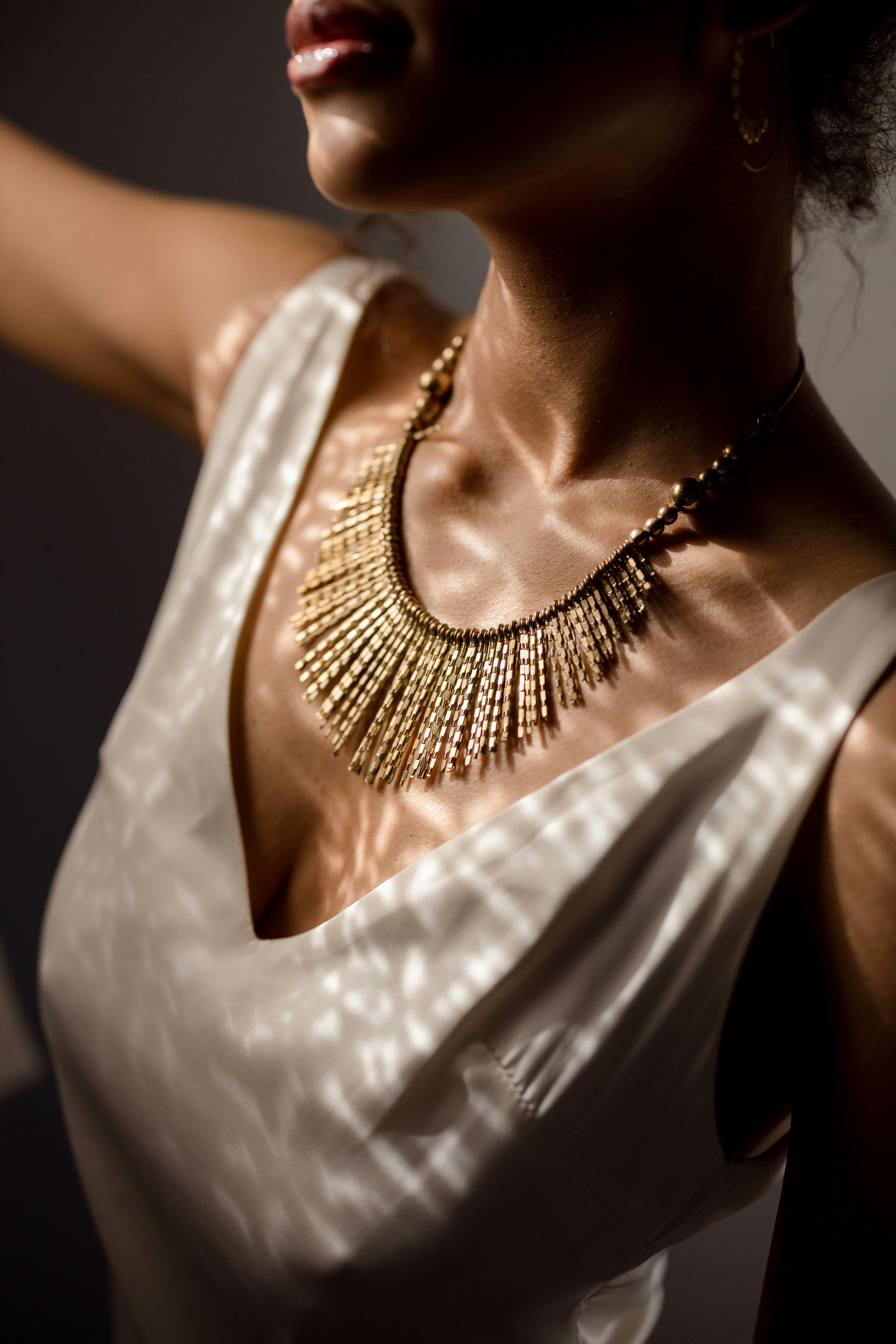 a woman wearing a gold necklace