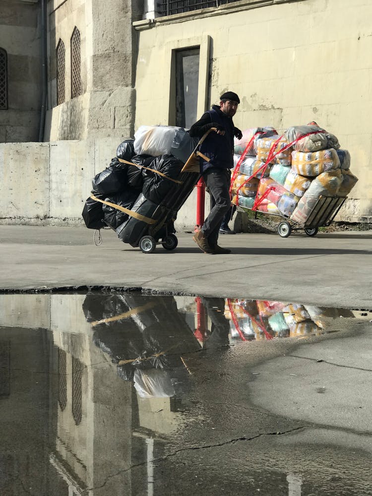 Man Towing Cart With Bags