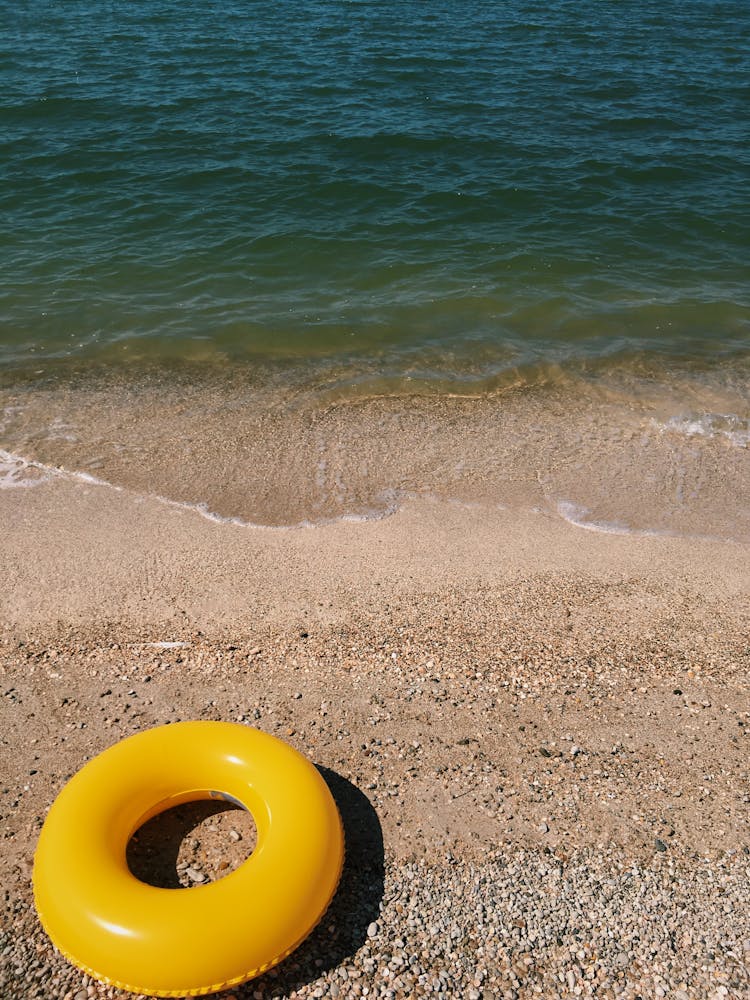Yellow Inflatable Ring On The Beach