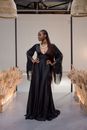 A Woman in Black Dress Posing while on the Runway
