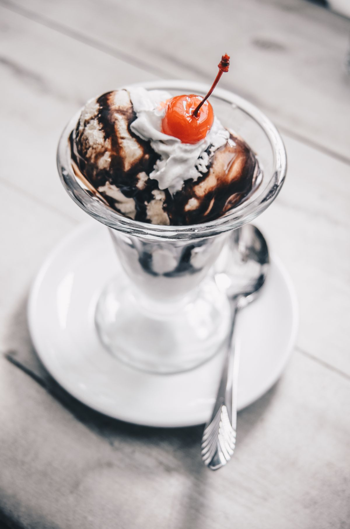 Ice cream sundae topped with whipped cream and a cherry