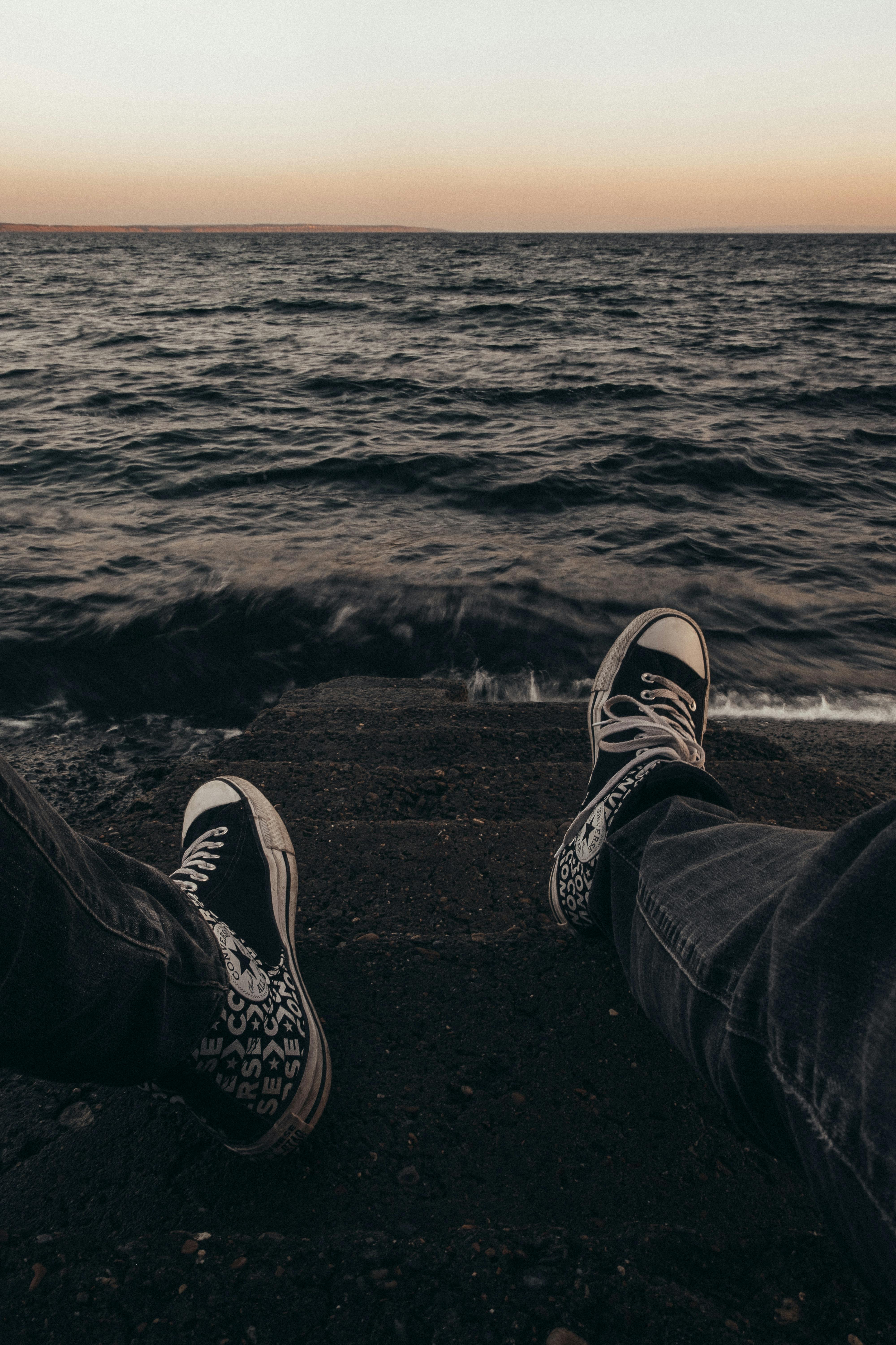 First Person View of a Man Sitting on Steps on the Seashore · Free Stock  Photo